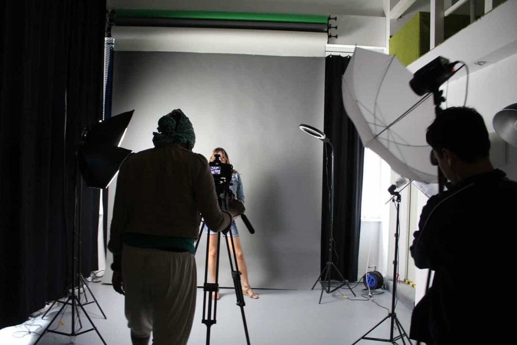 Kamera, Lichtschirme und Beteiligte bei einer Aufnahme im Studio der Kreativwerkstatt.